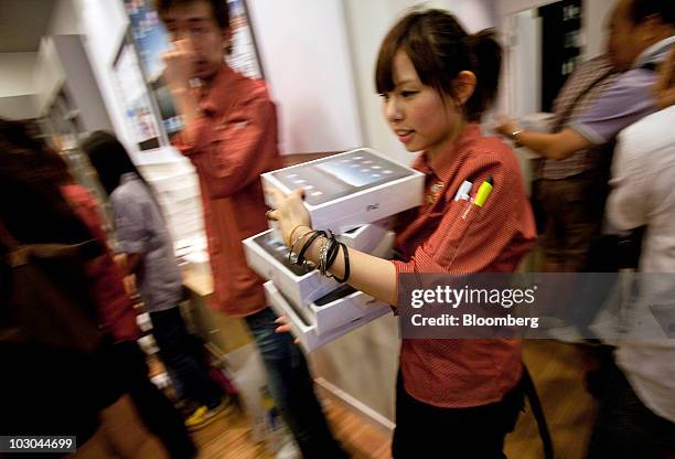 Store employee carries a stack of Apple Inc.'s iPad boxes at a store in Hong Kong, China, on Friday, July 23, 2010. As Apple begins selling the iPad...