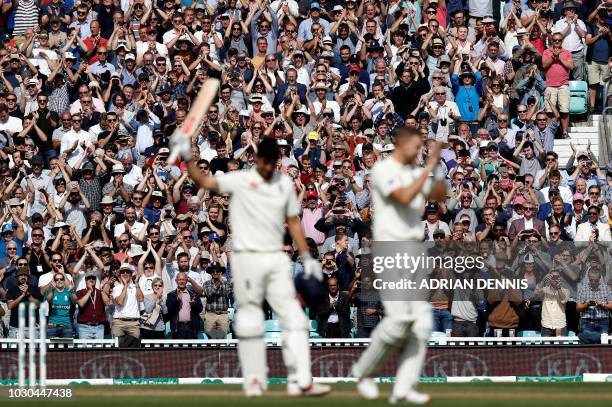 England's Alastair Cook acknowledges the applause from the crowd as he celebrates his century during play on the fourth day of the fifth Test cricket...