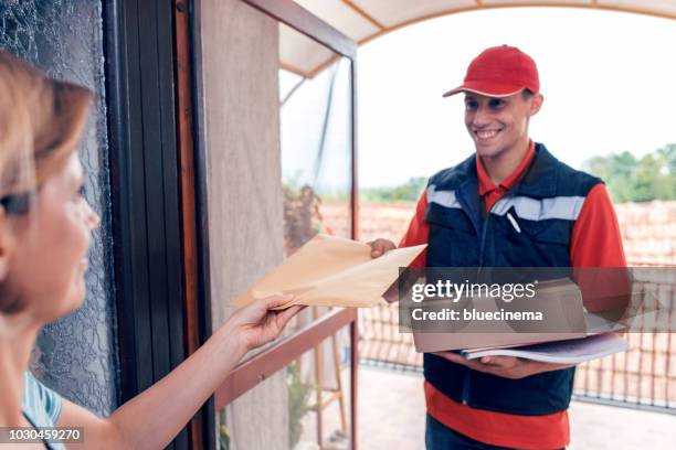 leveren van een pakket courier - postbode stockfoto's en -beelden