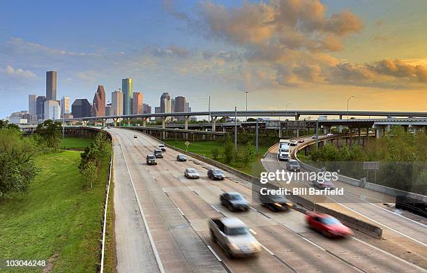 blurred cars on freeway leaving downtown area  - downtown houston stock pictures, royalty-free photos & images