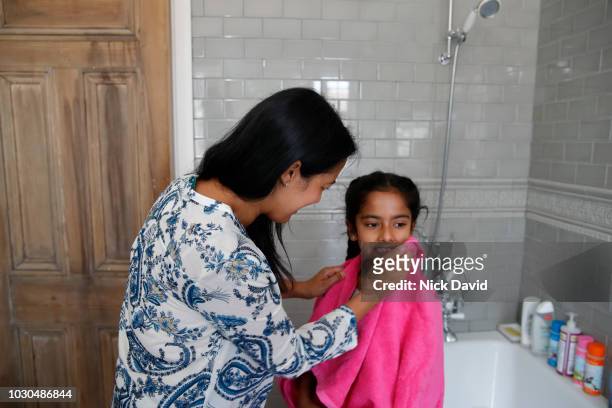 mother drying daughter after bath - kid bath mother stock-fotos und bilder