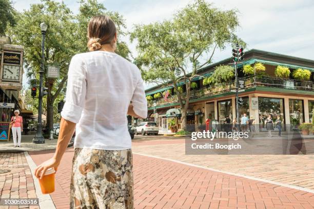 donna con coffee walking park avenue nel centro di winter park florida usa - winter park florida foto e immagini stock