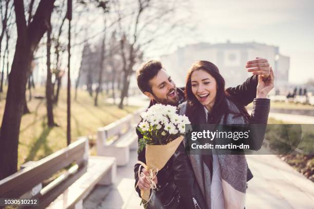 coppia che esce a san valentino - man giving flowers foto e immagini stock