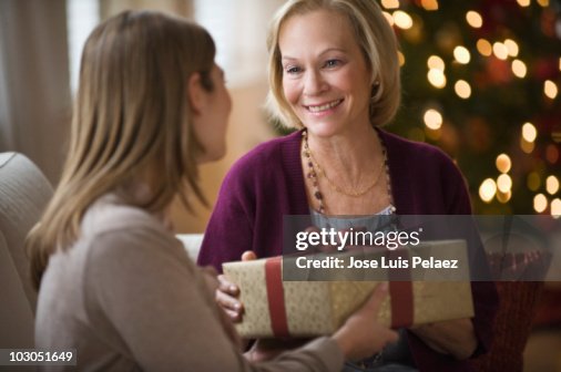 Mother and daughter sitting on the couch exchangi Mother and daughter sitting on the couch exchangi