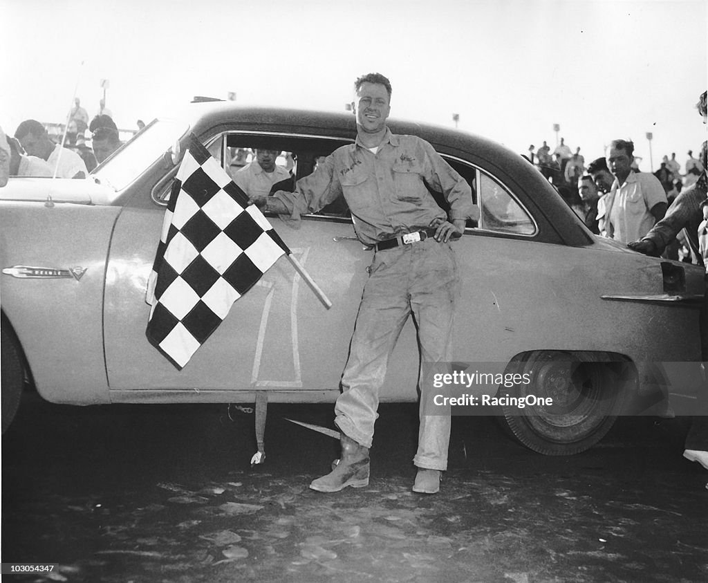 Jim Reed displays the checkered flag after a win early in his racing ...