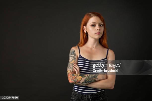 studio portrait of a tattoo artist on a black background - girl arms crossed stock pictures, royalty-free photos & images