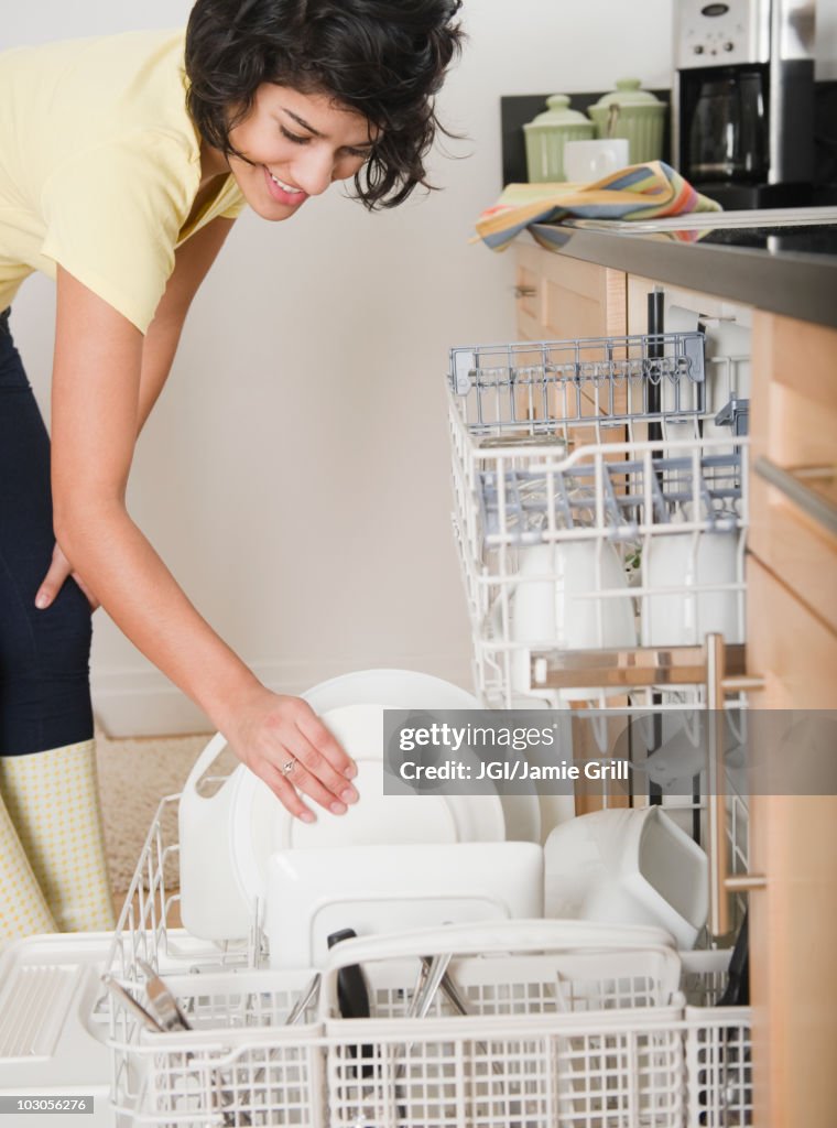 Hispanic woman putting dishes in dishwasher
