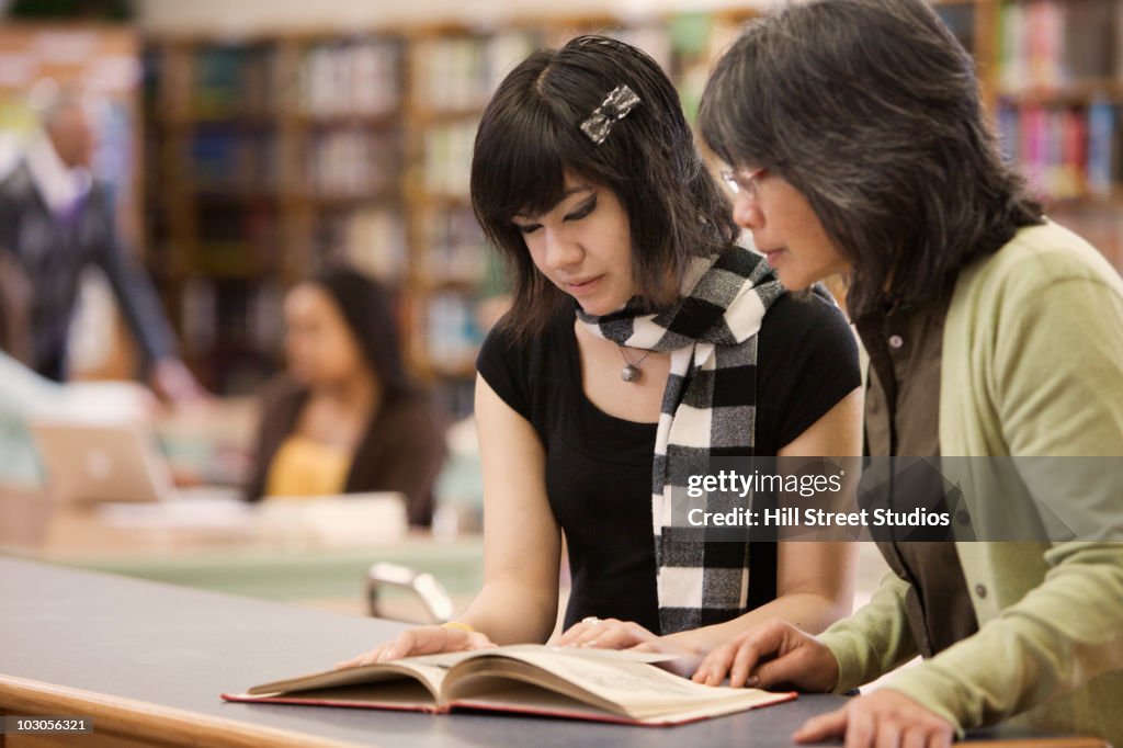 Filipino librarian helping student in school library