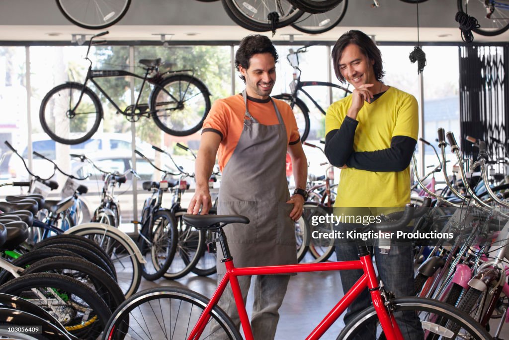 Bike shop owner helping customer choose bicycle