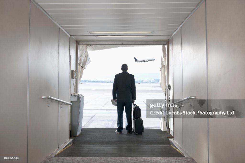 Hispanic businessman standing on jetway