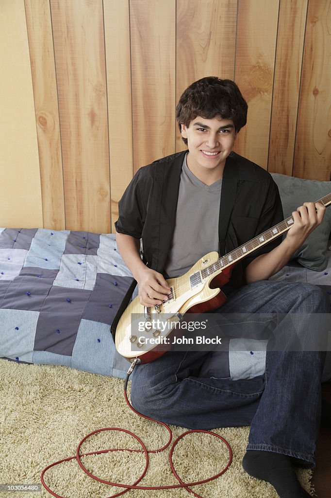 Native American teenager playing electric guitar