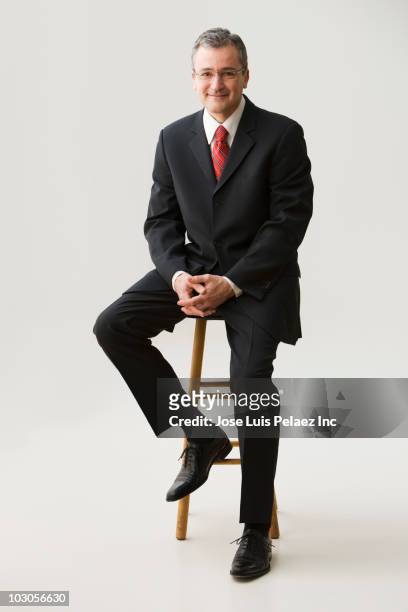 caucasian businessman sitting on stool - homme en pied fond blanc photos et images de collection