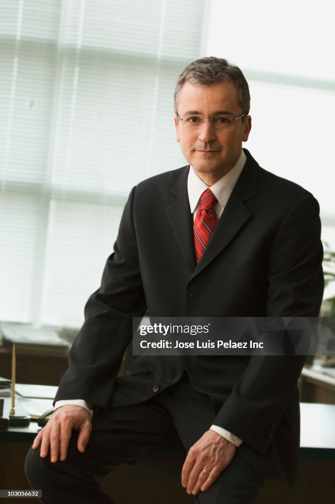Caucasian businessman sitting on desk