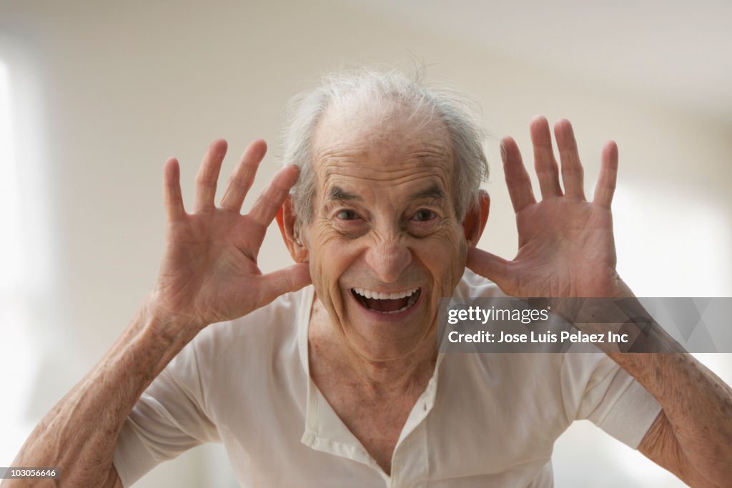 Senior Hispanic man making silly gesture