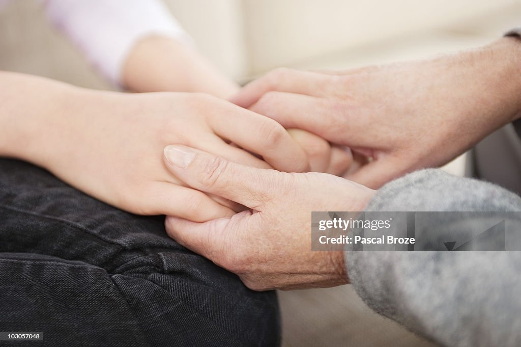 Woman holding hands of her granddaughter