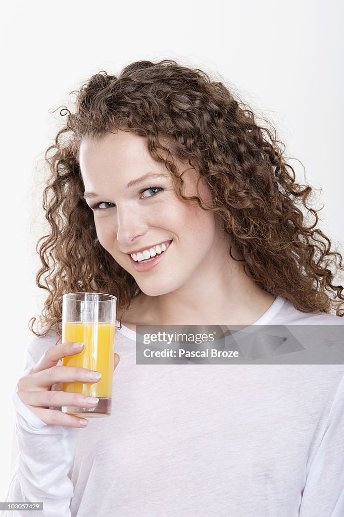 Portrait of a woman holding a glass of orange juice