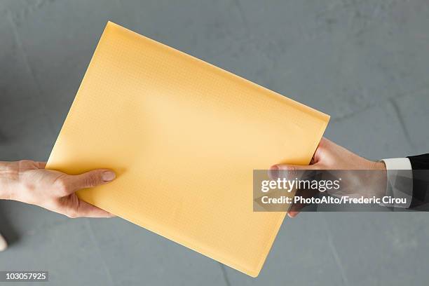 handing colleague large brown envelope - large envelope stock pictures, royalty-free photos & images