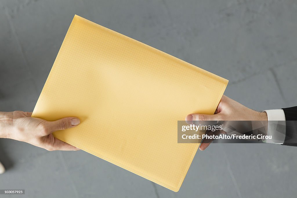Handing colleague large brown envelope