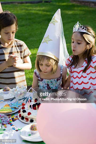 girl blowing out candles on birthday cake at outdoor birthday party - boy tiara stock pictures, royalty-free photos & images