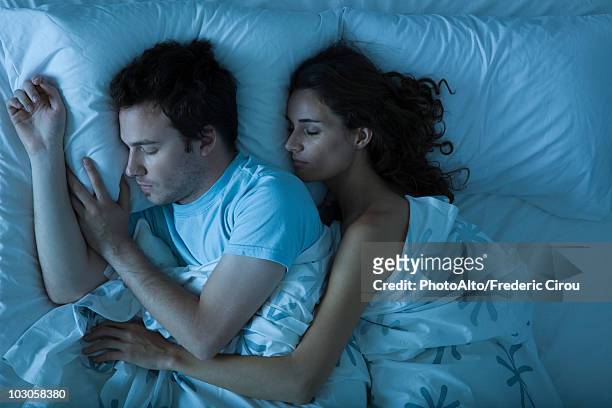 couple sleeping, woman embracing man - man and woman cuddling in bed stockfoto's en -beelden