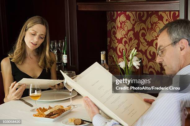 mature couple looking at menus in restaurant - choosing wine stock pictures, royalty-free photos & images