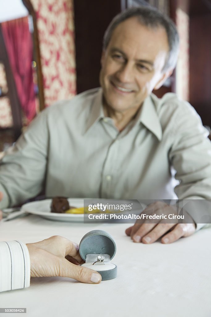 Mature man giving woman diamond ring, cropped