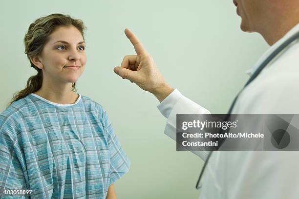 doctor testing patient's ocular responsiveness - doctor arms raised stock pictures, royalty-free photos & images