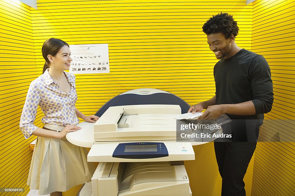 Business executives using photocopy machine in an office