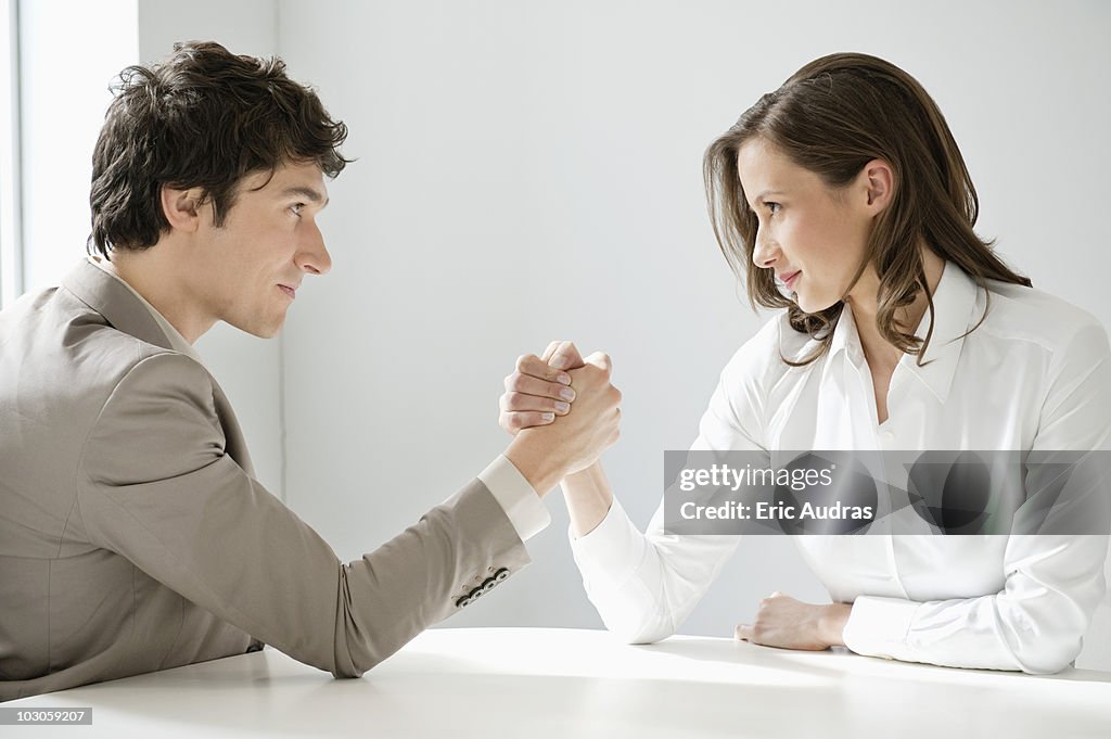 Businessman arm wrestling with a businesswoman