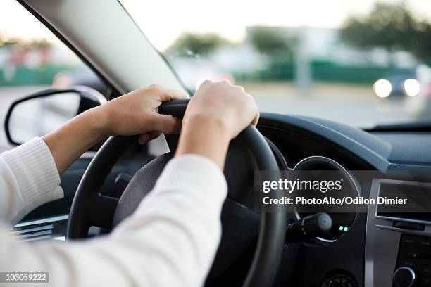 driving car with both hands on the steering wheel - steering wheel stock-fotos und bilder