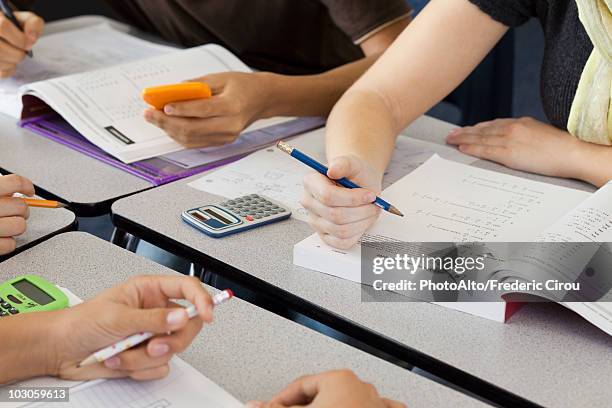 students completing mathematics assignment together, cropped - libro de texto fotografías e imágenes de stock