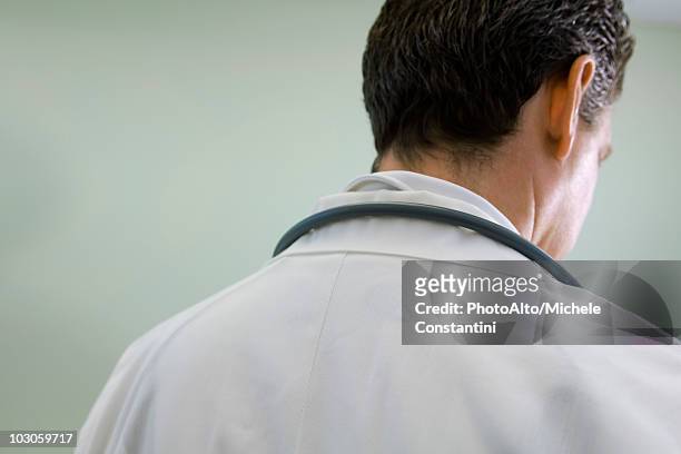 doctor contemplatively looking down - doctor looking down stock pictures, royalty-free photos & images