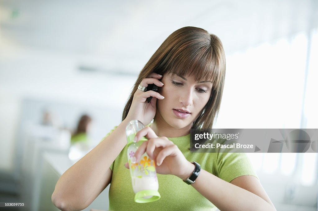 Businesswoman talking on a mobile phone and checking the time