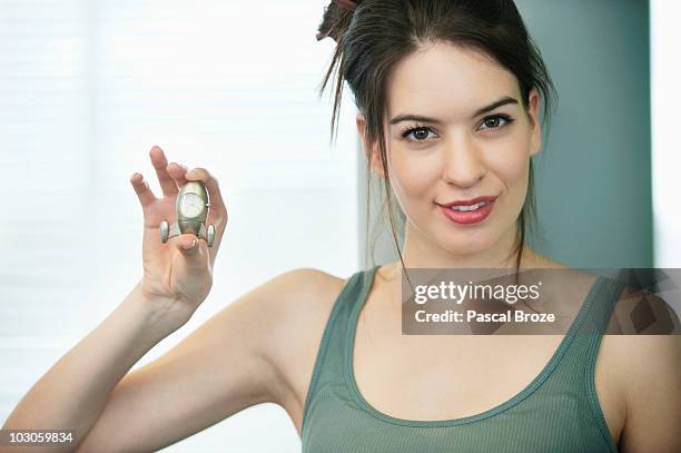 portrait of a woman showing a clock and smiling - woman vest stock pictures, royalty-free photos & images