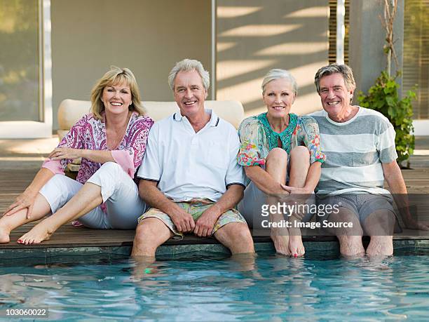 mature friends by swimming pool - baby boomer stock pictures, royalty-free photos & images