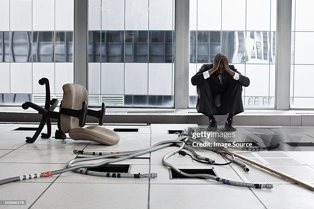 Despairing businessman in abandoned office