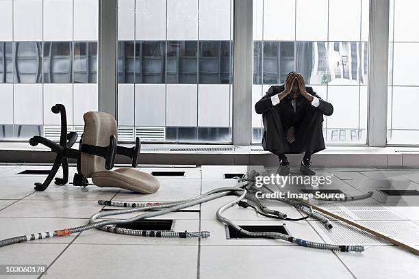 despairing businessman in abandoned office - chaos büro stock pictures, royalty-free photos & images