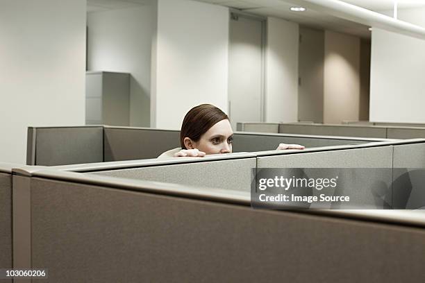 woman hiding behind cubicle in office - gömma bildbanksfoton och bilder