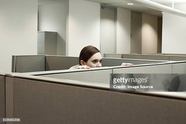 woman hiding behind cubicle in office - 陰謀 個照片及圖片檔