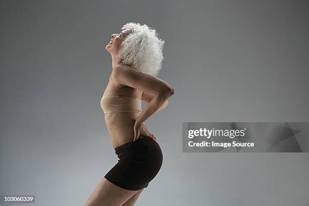 mature woman touching back - one woman only shorts 50s stock pictures, royalty-free photos & images