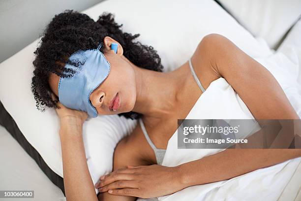 woman sleeping in eye mask and ear plugs - masque pour les yeux photos et images de collection