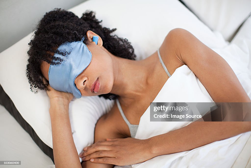 Woman sleeping in eye mask and ear plugs