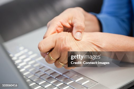 Laptop and woman with pain in hand Laptop and woman with pain in hand