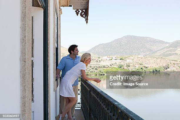 couple on balcony overlooking douro river - hotel balcony stock-fotos und bilder