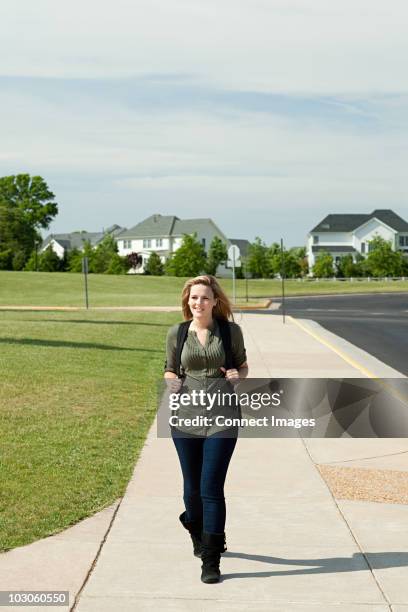 female high school student walking along pavement - prince william county virginia stock pictures, royalty-free photos & images