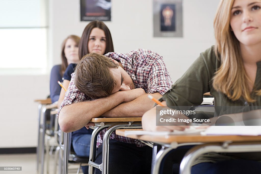 Male high school student asleep in class