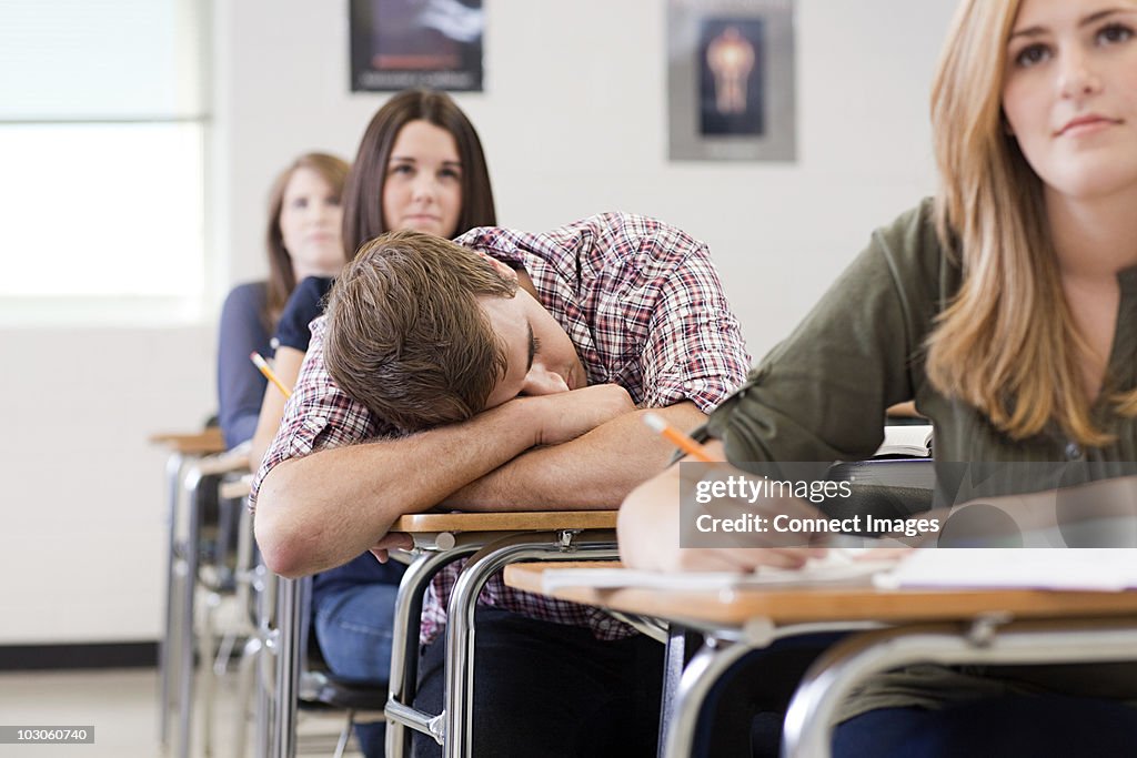 Male high school student asleep in class