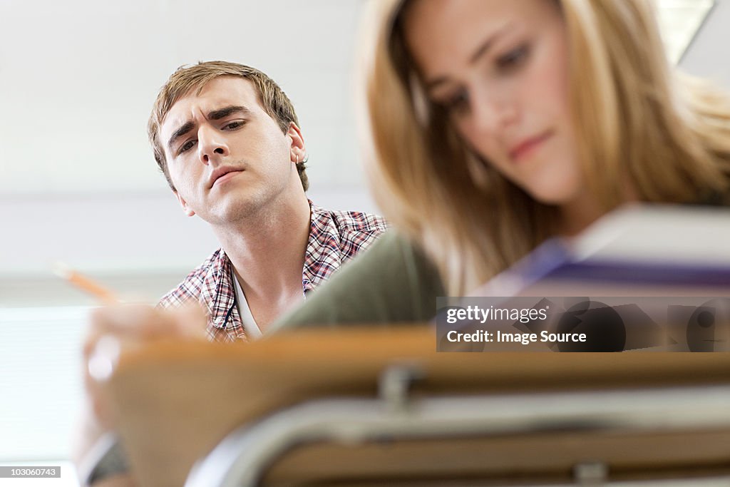 Male high school student copying classmate's work
