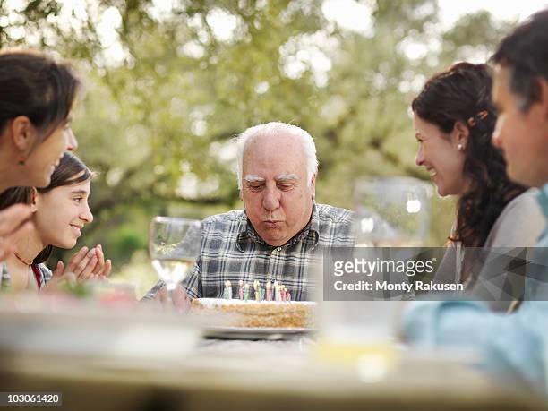 senior man with birthday cake - senior birthday stock pictures, royalty-free photos & images
