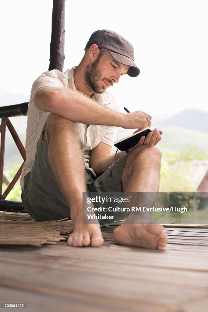 Man writing in travel journal